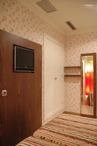 a bedroom with a bed and a tv on a wall at Hotel Ideal in Villarrobledo