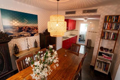 a kitchen with a dining room table with flowers on it at Casa Aguila Ibiza in Cala Vadella