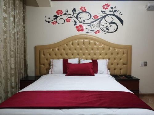 1 dormitorio con 1 cama grande con almohadas rojas en Hotel Wayra, en Lima