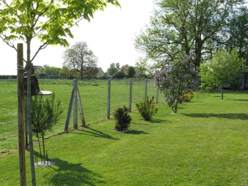 a garden with trees and flowers in a field at Chambre d'hôtes La Clé du Bonheur in Manthelon