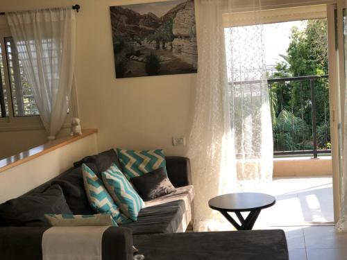 a living room with a couch and a window at Rivkas zimmer in Ein Gedi