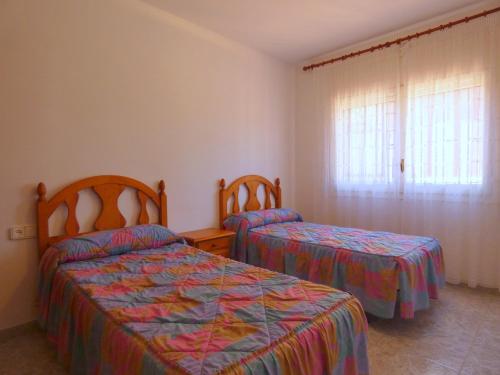 a bedroom with two beds and a window at Rentalmar Chalet Dalias in Montroig