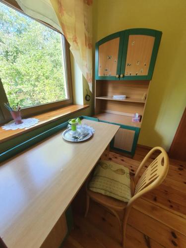 a room with a wooden table and a window at Agroturystyka LAS i WODA in Prażmów