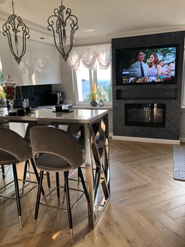 a living room with a dining table and a tv on a fireplace at Apartament Primavera z sauną in Kielce
