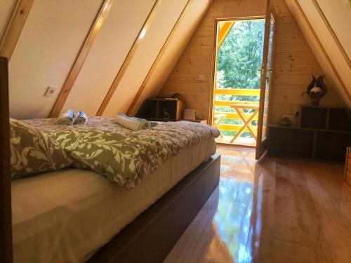 a bedroom with a bed in a wooden house at Dren Chalet Lux - Banjska stena in Perućac