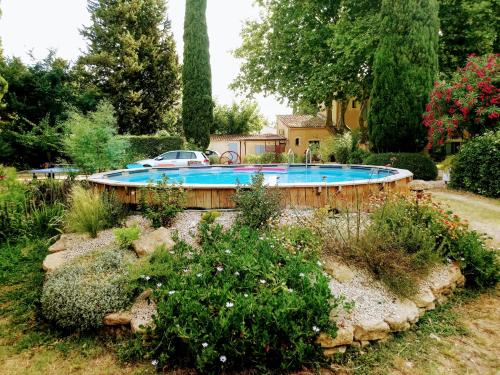 una piscina en medio de un jardín en La Petite Seigneurette, en Villeneuve-lès-Avignon