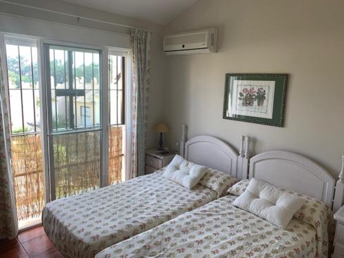 1 Schlafzimmer mit 2 Betten vor einem Fenster in der Unterkunft Golf Chalet Islantilla in Islantilla