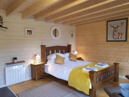 a bedroom with a bed in a room with wooden walls at An Traigh Cabin in Portree