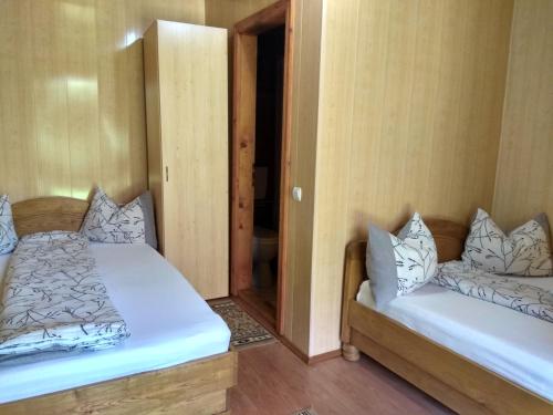 a room with two beds and a door to a bathroom at Casa Adriana in Săpînţa