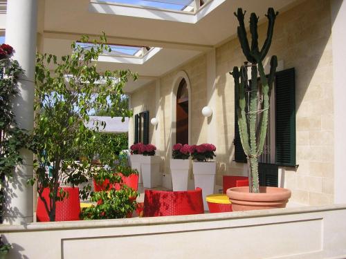 a patio with red chairs and potted plants at Leziedipiero in Nardò