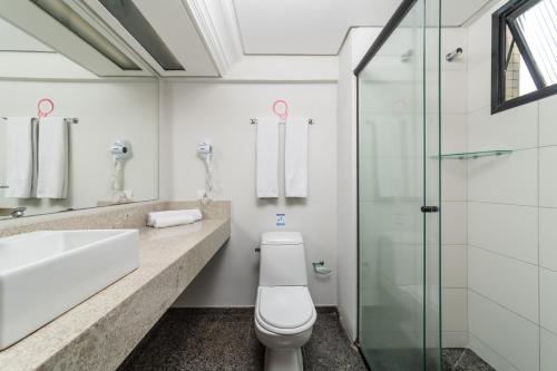 a bathroom with a toilet and a sink and a shower at Rede Andrade Vernon in Curitiba