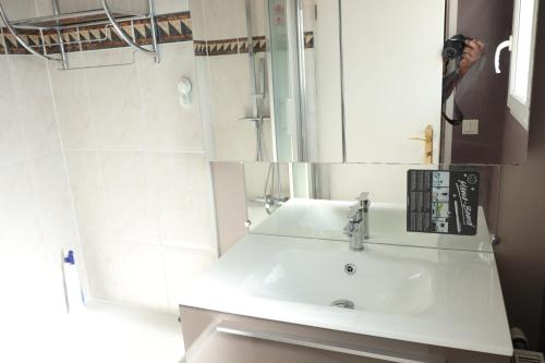 La salle de bains est pourvue d'un lavabo blanc et d'un miroir. dans l'établissement Ma Grace, à Savigny-le-Temple