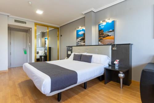 a bedroom with a large bed and a couch at Chateau La Roca in Sancibrián