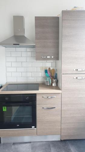 a kitchen with wooden cabinets and a stove at The Bachelor Backpacker Spot in Brussels