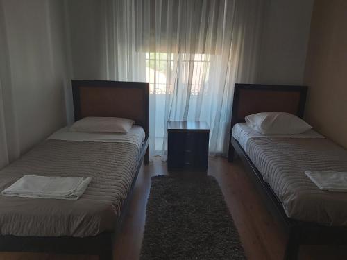 a hotel room with two beds and two lamps at Areia Da Foz in Figueira da Foz