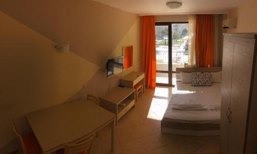 サニービーチにあるRoyal Sun - Sunny Cove Apartmentのベッドと窓が備わる小さな客室です。