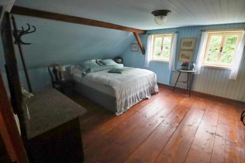 Schlafzimmer mit einem Bett mit blauen Wänden und Holzböden in der Unterkunft Chalupa Huníkov in Huníkov