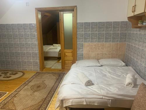 a bedroom with a white bed and a mirror at Rustic Apartament in Moisei