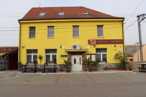 a yellow building with a white door on a street at Hotel u Nádraží Lanžhot in Lanžhot
