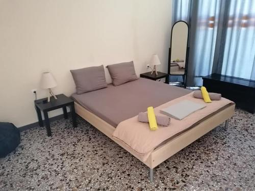 Bett in einem Zimmer mit 2 Tischen und einem Spiegel in der Unterkunft Savvas in Nafplio