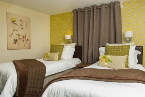 a hotel room with two beds and curtains at Battlesteads in Wark