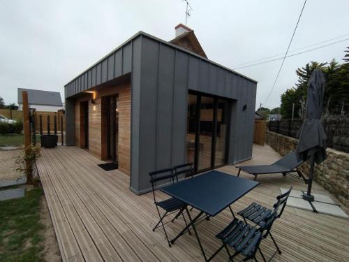 a tiny house with a table and chairs on a deck at Les Villas de Locmiquel BORD DE MER in Baden