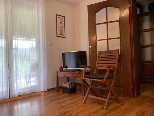 een kamer met een bureau met een stoel en een televisie bij Apartment Savkovic in Šipovo