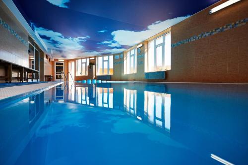 - une piscine avec éclairage bleu dans un bâtiment dans l'établissement Hotel Slunce, à Rýmařov