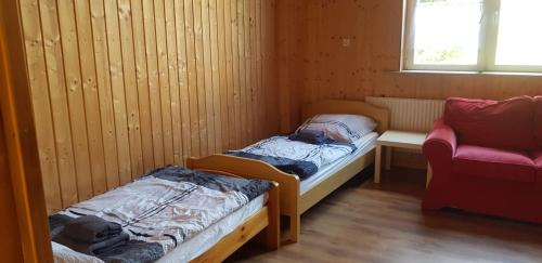 Cette petite chambre comprend deux lits et une chaise. dans l'établissement Niederdreisbacher Hütte - moderne Doppelzimmer - EINZELBETTEN -, à Niederdreisbach