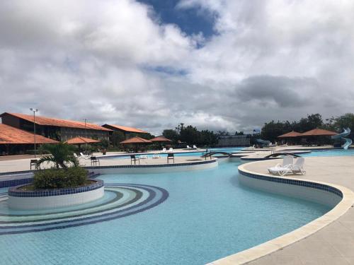 a pool at a resort with chairs and umbrellas at HOTEL CANARIUS DE GRAVATA - Flat in Gravatá