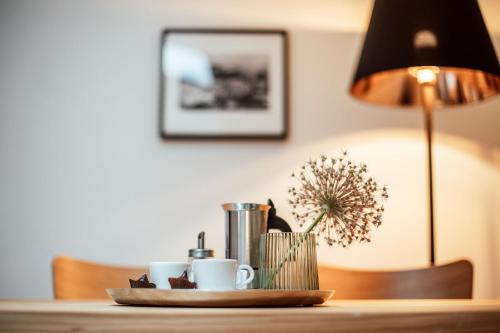 a table with two coffee cups and a lamp at the salt residences in Hallein