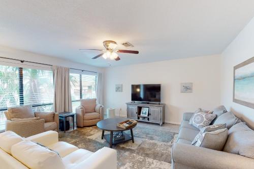 sala de estar con muebles blancos y ventilador de techo en Beachview, en Navarre