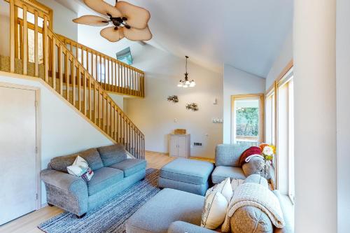 a living room with two couches and a staircase at Tanya's Beach Retreat in Pacific City