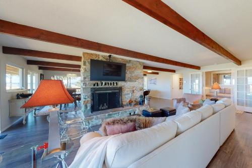 a living room with a white couch and a stone fireplace at Baydream in Westport