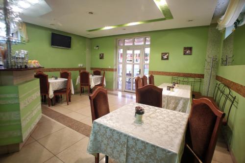 a restaurant with tables and chairs and green walls at U Anity in Uzhhorod