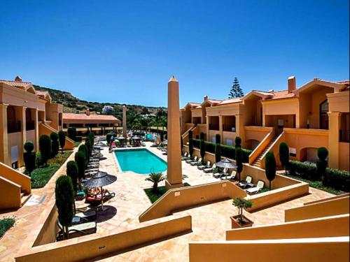 une cour d'un hôtel avec une piscine dans l'établissement Praia da Luz Mar e Sol Apartamento, à Luz