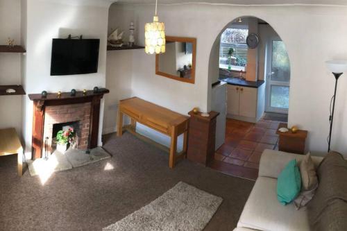 een woonkamer met een bank en een open haard bij Attractive 2 bed cottage in Hempton Fakenham in Fakenham