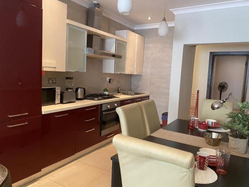 cocina con mesa con sillas y encimera en [B] Bakerstreet - Beautiful Two Bedroom Apartment en Accra