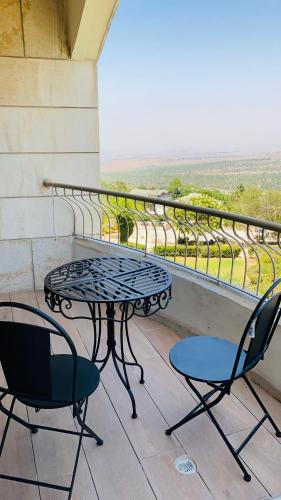 a table and chairs on a balcony with a view at pisgat shoresh in Shoresh