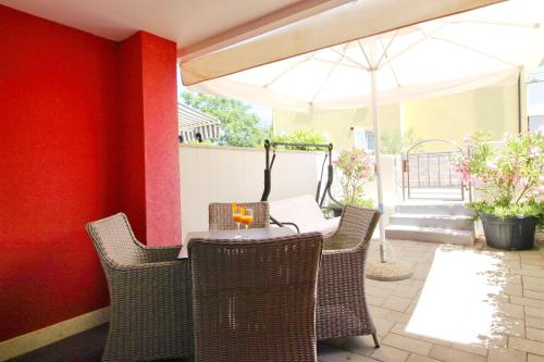 a patio with a table and chairs and an umbrella at Villa Pino with Pool, Sauna & Jacuzzi in Petrcane