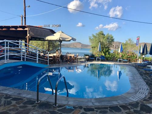 a pool at a resort with a view of the water at Lena Apartments in Elounda