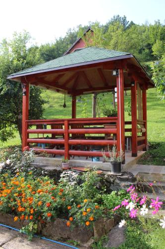 a wooden gazebo in a garden with flowers at Apartment Sijakovic in Mokra Gora