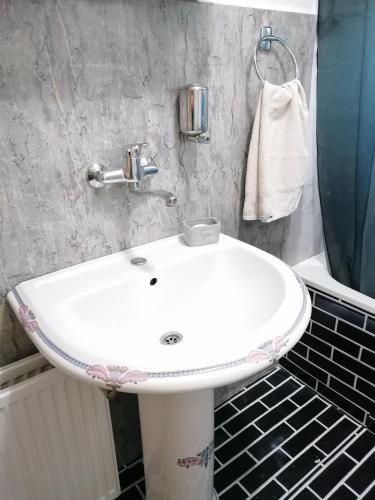 a bathroom with a white sink and a towel at Apartment ELLA in Tuzla