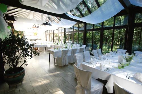 jadalnia z białymi stołami i krzesłami w budynku w obiekcie Wald-Café Hotel-Restaurant w mieście Bonn
