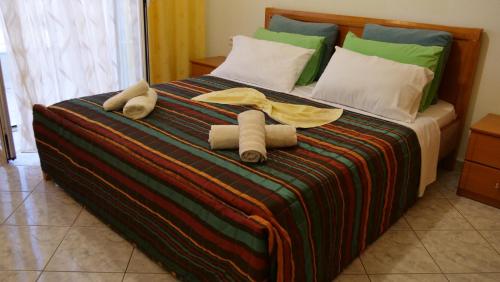a bed with two towels and pillows on it at Isabela Apartments in Sarandë