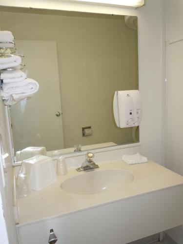 a bathroom with a sink and a mirror at Travelodge by Wyndham Grand Rapids North in Grand Rapids