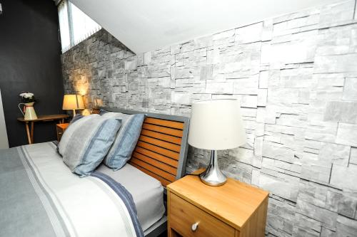 a bedroom with a bed with a stone wall at Maryland in Derby