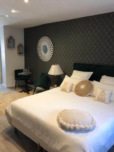 a bedroom with a large white bed and a desk at Cloutiers26 in La Rochelle