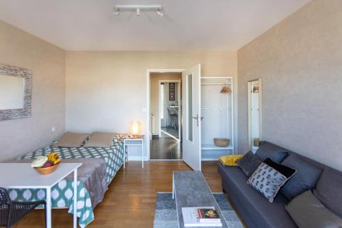 un salon avec un canapé et une table dans l'établissement Cocon, vue Rodez, terrasse, box, musée Soulages, à Rodez