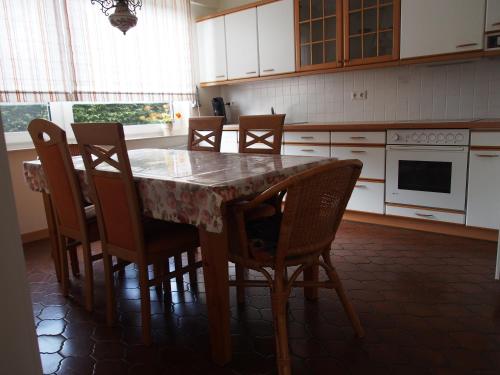 a kitchen with a wooden table with chairs and a tableablish at Ediths Haus in Rhauderfehn